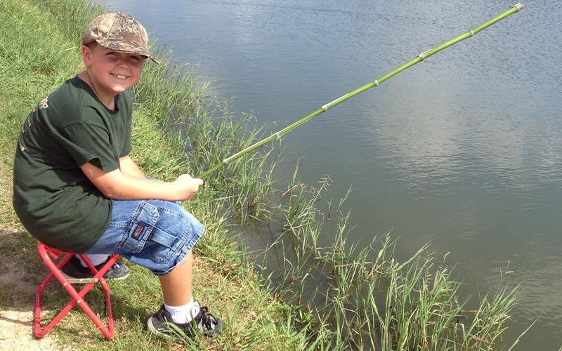 Boy fishing during Kid's Resort summer camp in Richmond, TX